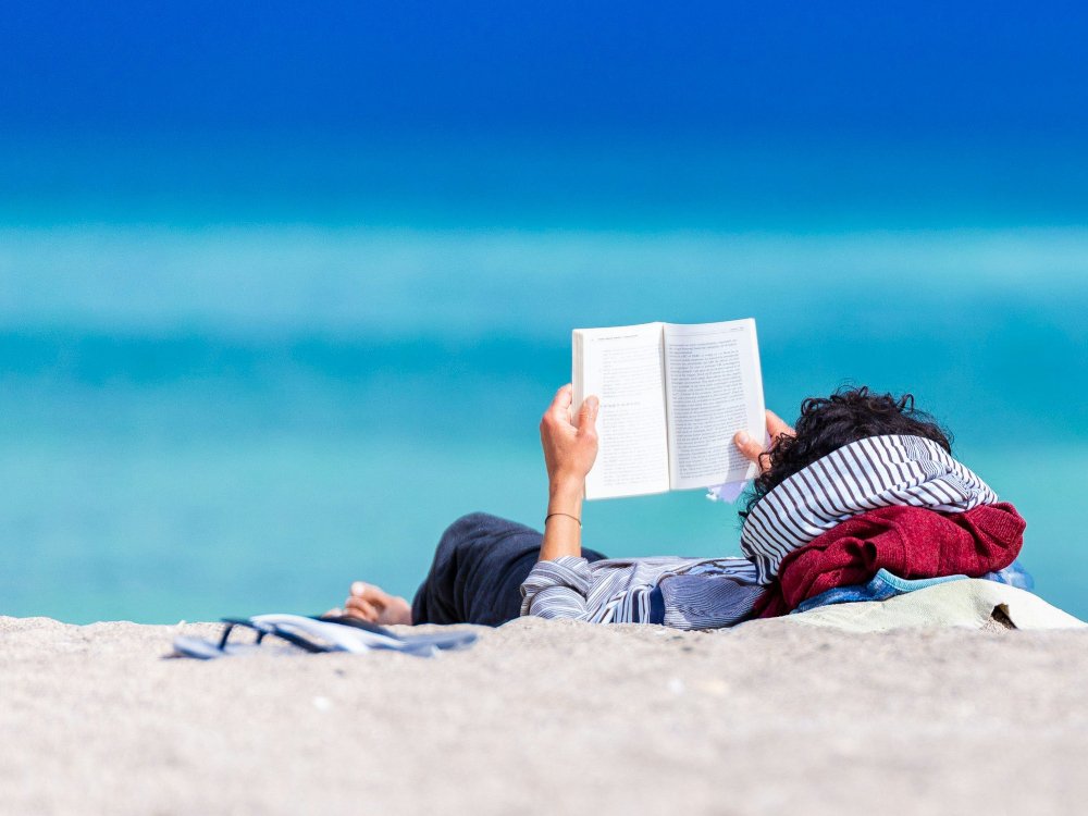 Lesen am Strand (c) Unsplash.com/Dan Dumitriu